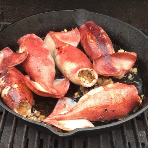 Squid cooked in a cast-iron pan on the BBQ